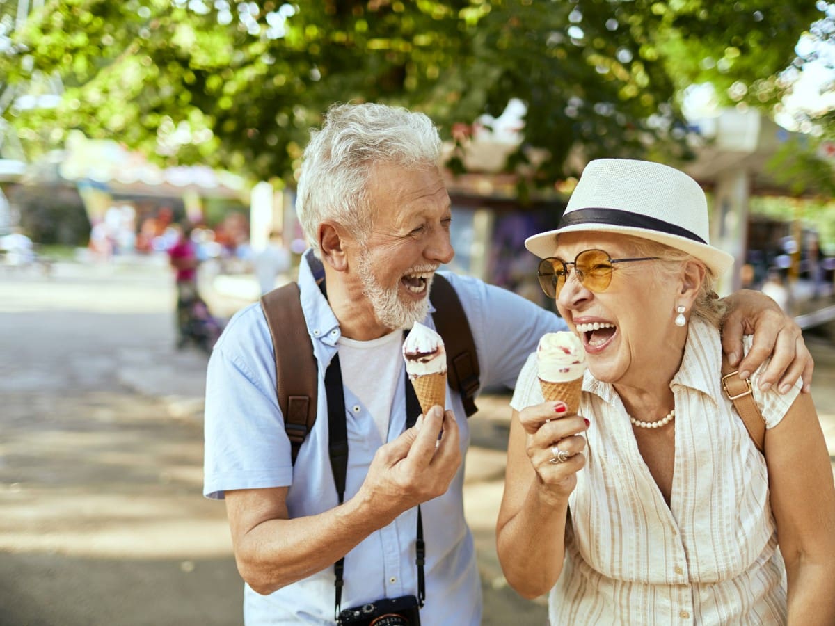 A man and woman eating ice cream on the street.