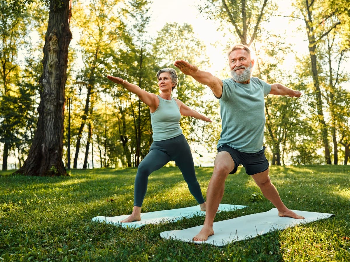 Two people doing yoga in the park